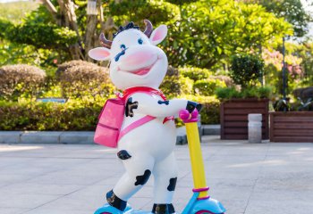 牛雕塑-幼兒園一只騎車(chē)背包的玻璃鋼卡通牛雕塑